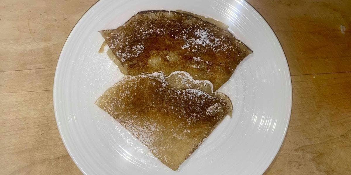 two crepes folded into triangles on a plate