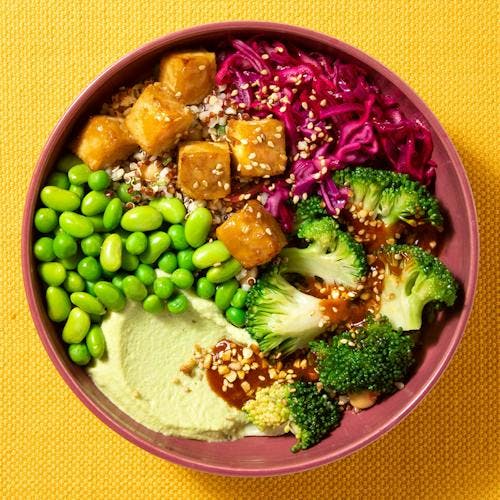 A top down image of the Protein Power Bowl dish in a pink bowl on a yellow table cloth background