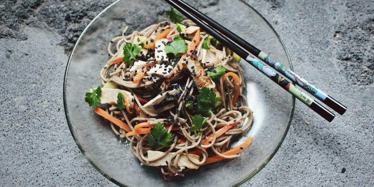 tofu and veg noodles on clear plate