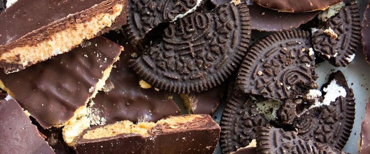 Close up image of broken oreos, chocolate digestives, and peanut butter cups.