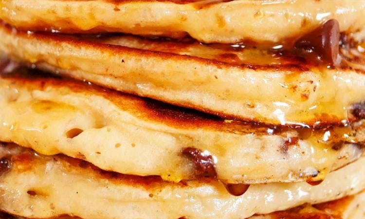 close up pancake stack with dripping syrup