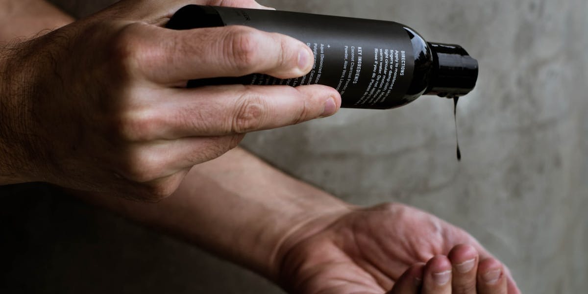 person holding haircare product bottle