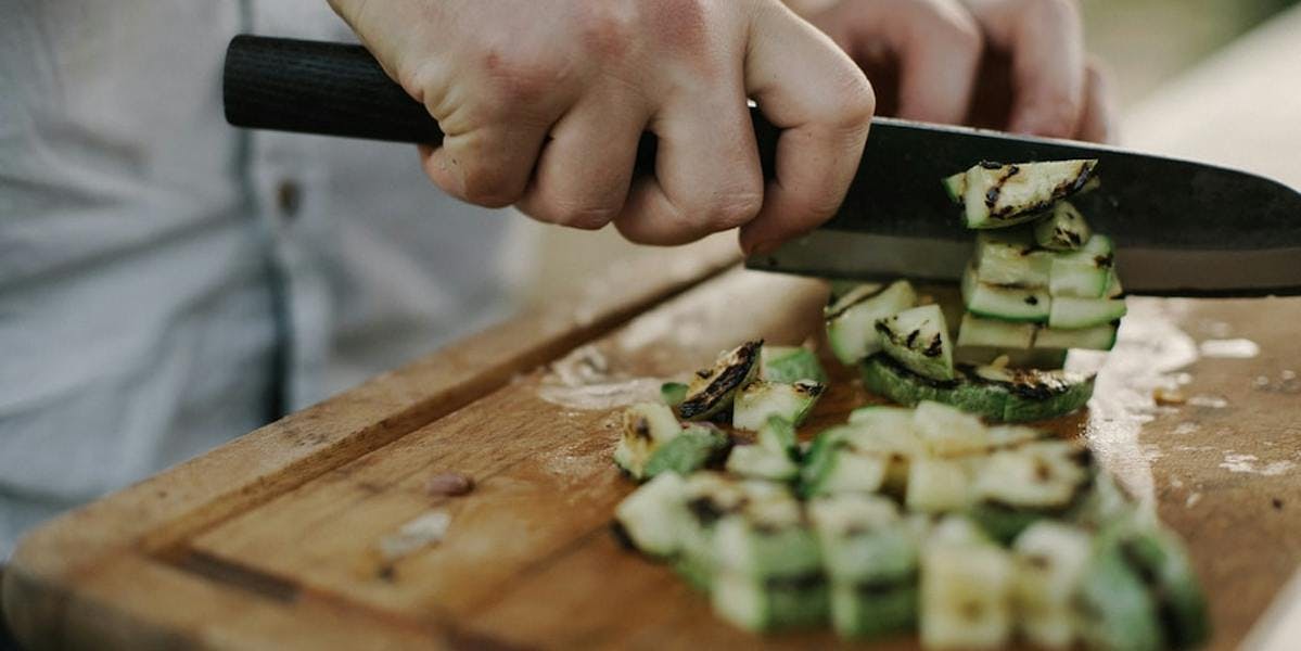 person chopping courgette