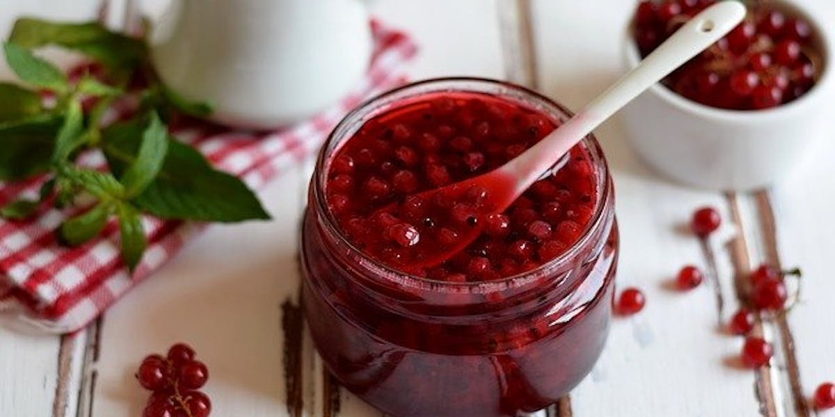 Jar of red currant jam with spoon