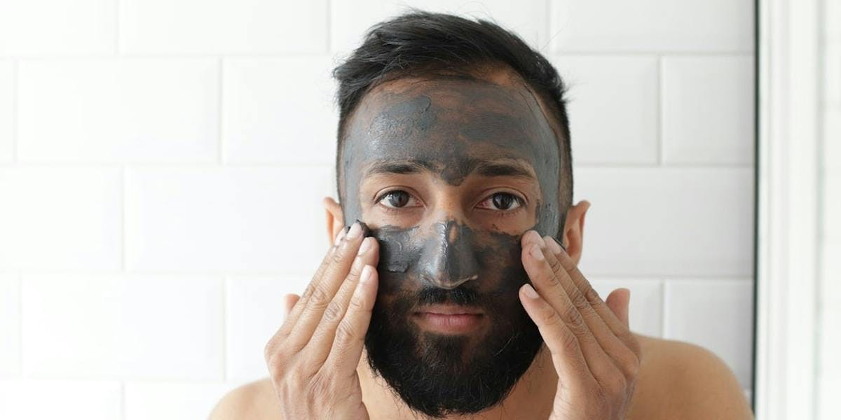 man with charcoal face mask