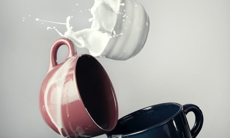 three cups with milk overflowing 