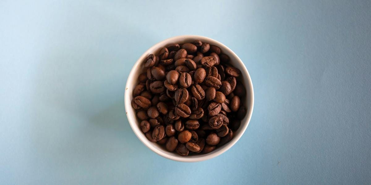a cup of whole coffee beans