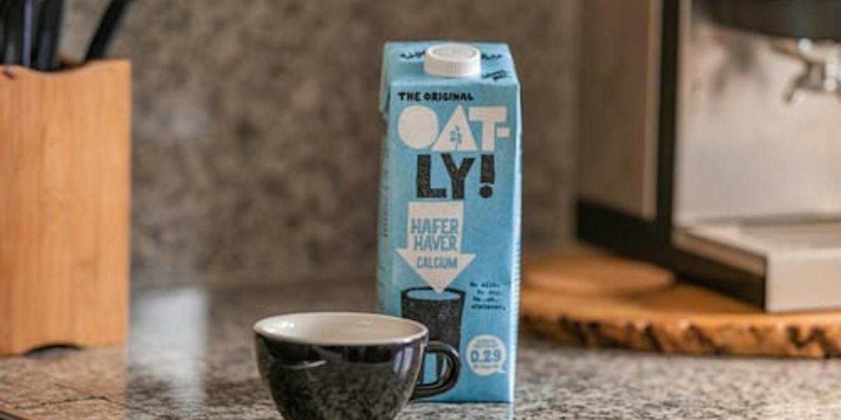 Oatly carton next to cup