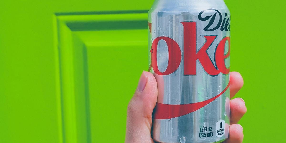 A can of diet coke in front of a green door