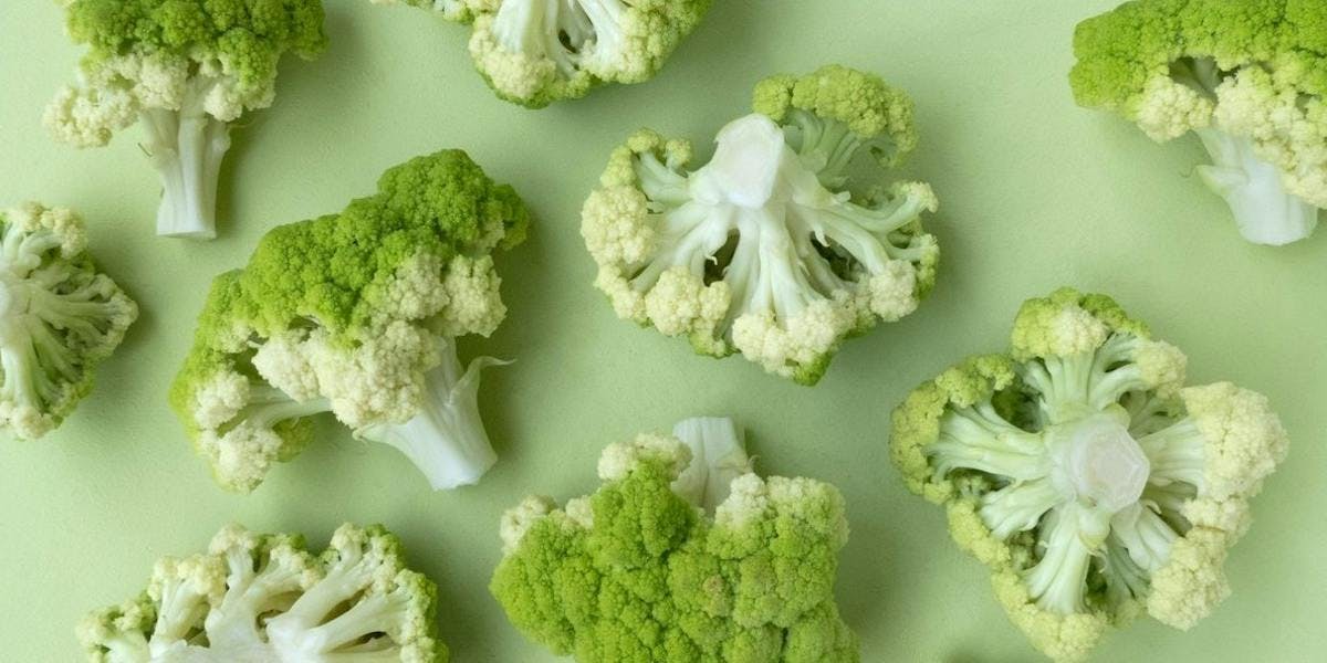 Chopped broccoli on green surface 