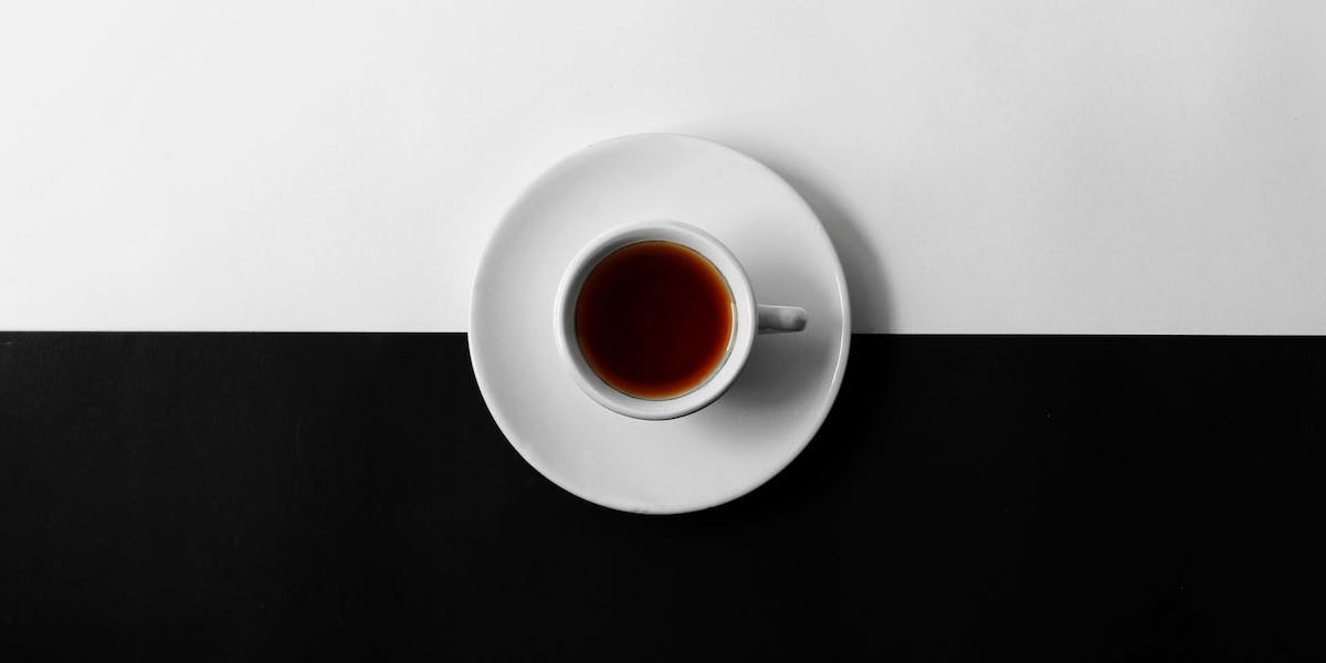 a cup of coffee on a black and white background