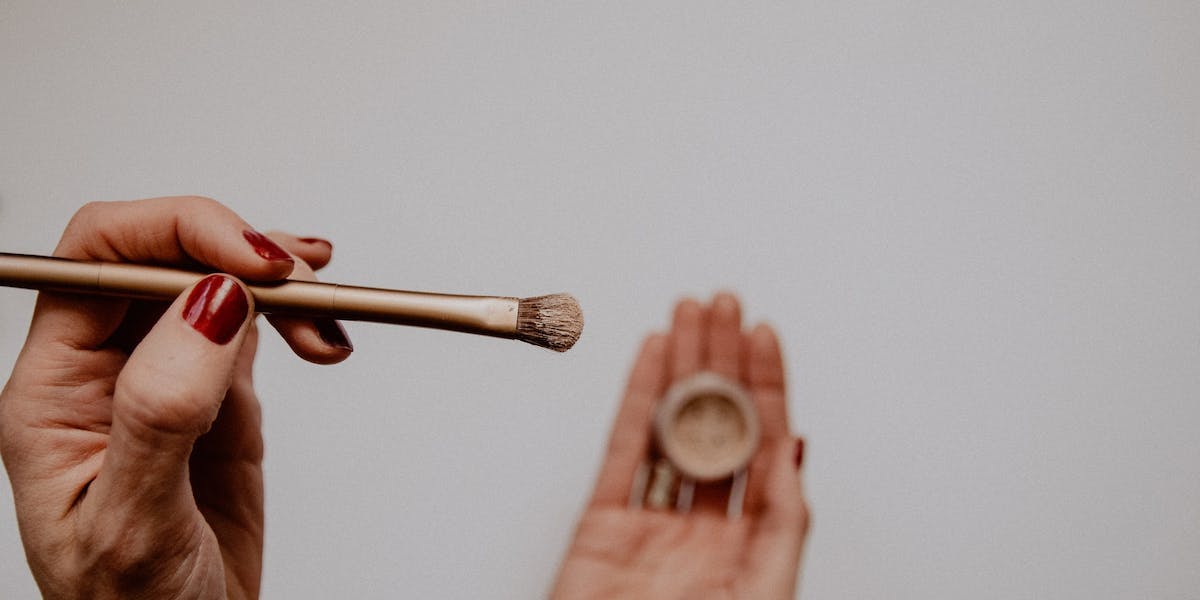 person holding makeup brush