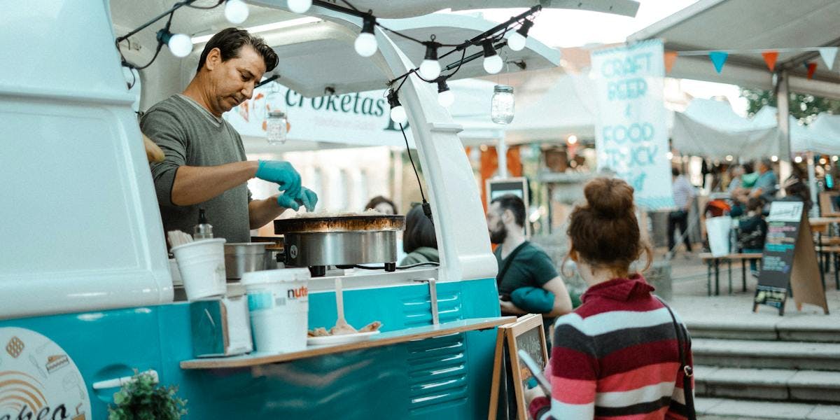 White and teal food truck in a market