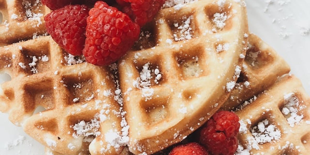 waffles with raspberries on top on a plate