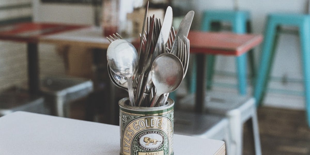 Tate and Lyle golden syrup can holding cutlery 