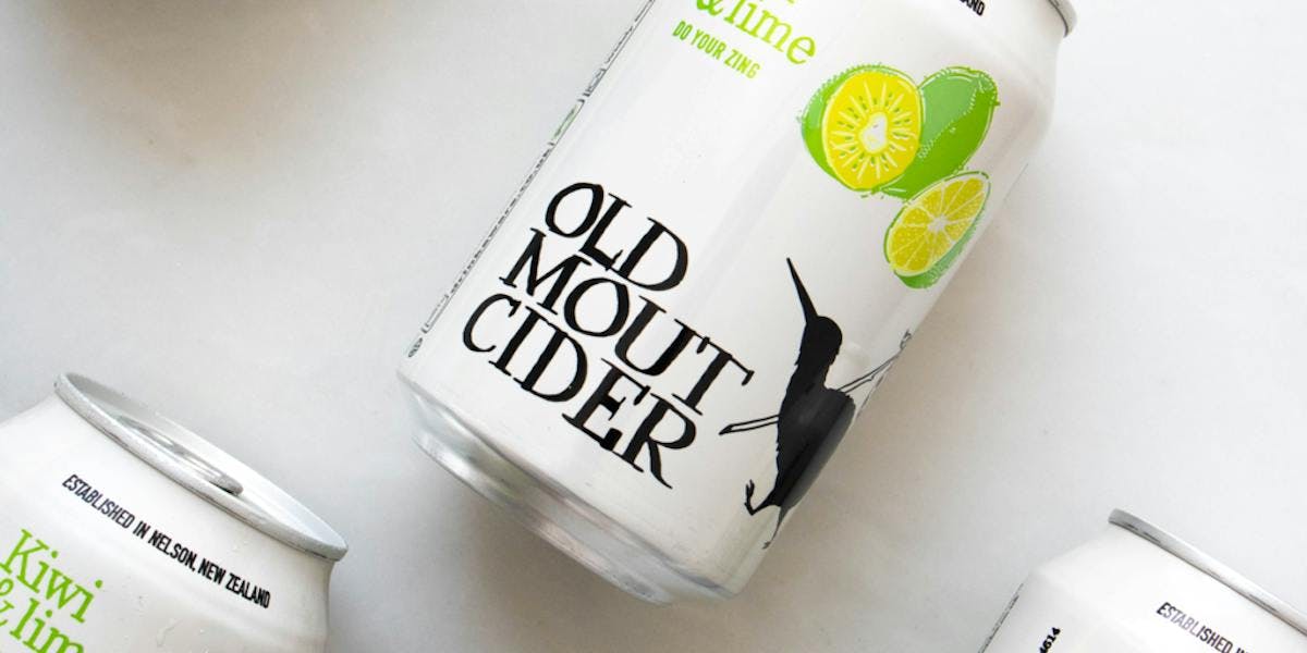 Image of cans of Old Mout cider, kiwi and lime flavour. Layed on a white table.